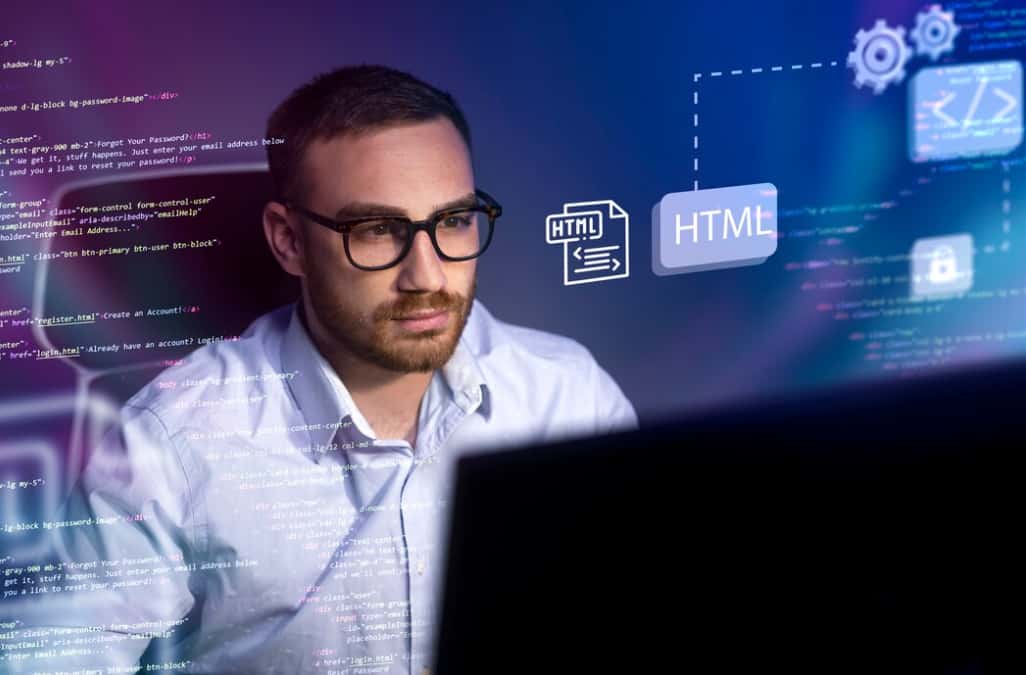 A man intently coding with HTML icons and code in the background